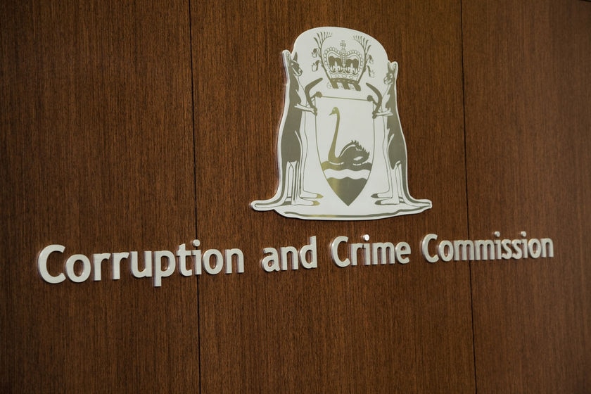A WA Government insignia and Corruption and Crime Commission sign on an indoor wall.
