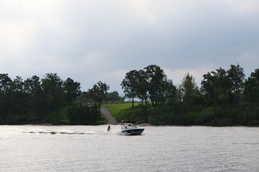 A man water skis on a river