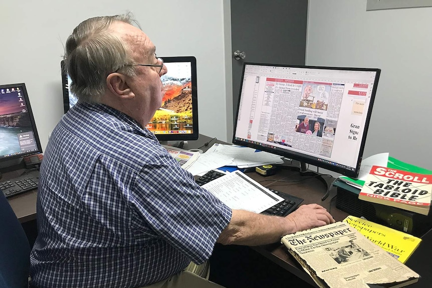 Colin Jackson sits at his desk with three computer screens surrounding while working on the digital copy of the Longreach Leader