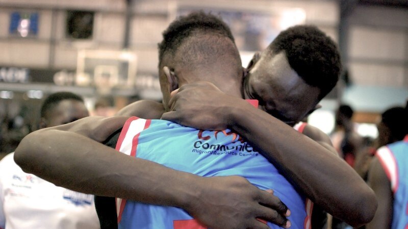 Two players from the Savannah Pride basketball club share a celebration hug.