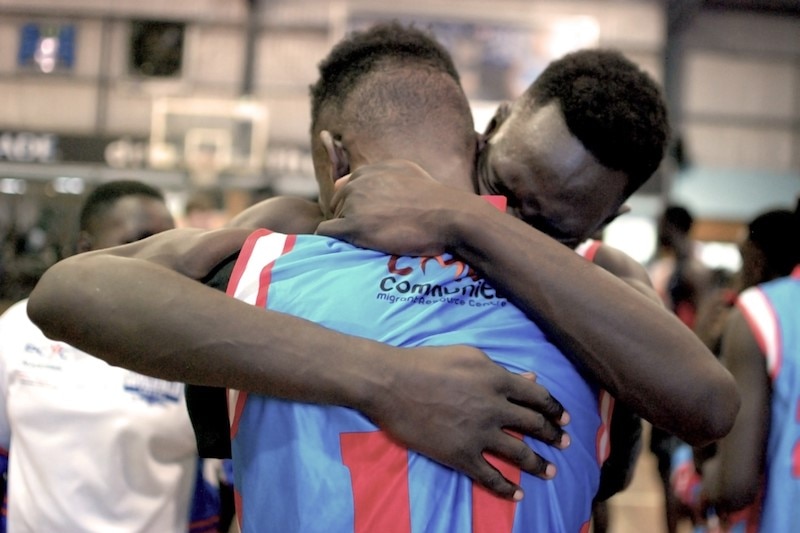 Two players from the Savannah Pride basketball club share a celebration hug.