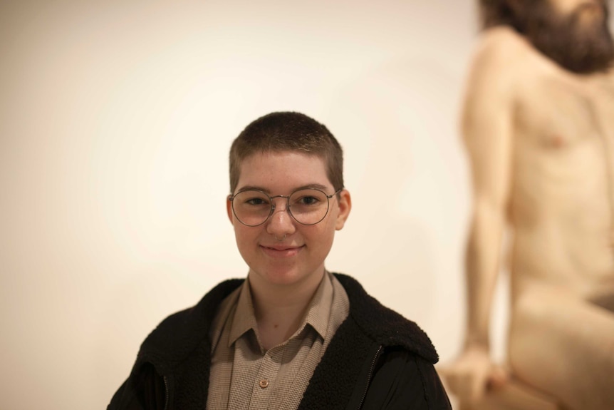 A woman, Caolin, standing in front of Ron Mueck's Wild Man sculpture, Art Gallery of NSW, 2016
