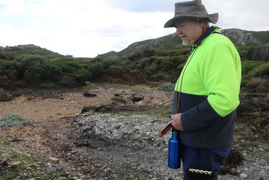 Caleb Pedder looks at a midden in the Arthur Pieman Conservation Area which has been damaged by vehicles