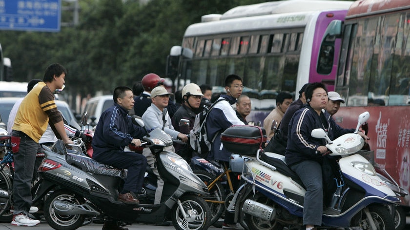 Chinese motorists on E-bikes on a road in Shanghai