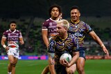 A rugby league player celebrates scoring a try 