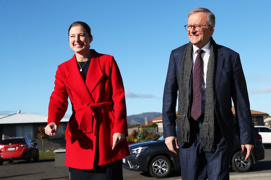 Julie Collins and Anthony Albanese both walk towards the camera, smiling.