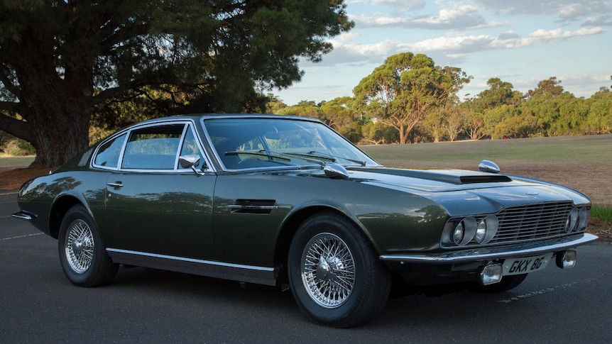 A beautifully polished olive green sports car, first built in the 60s