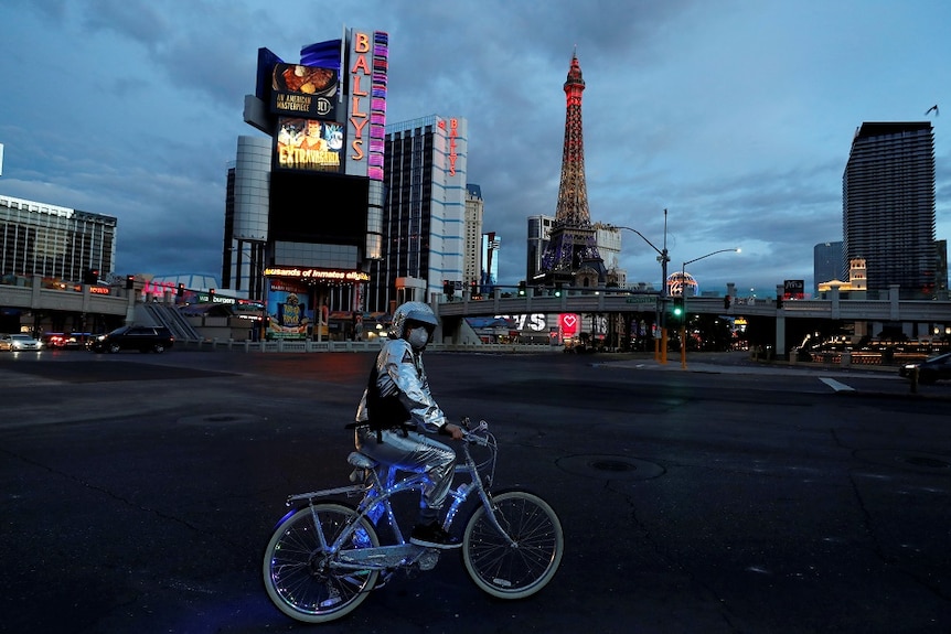 A man stands on his bicycle in a deserted Las Vegas location