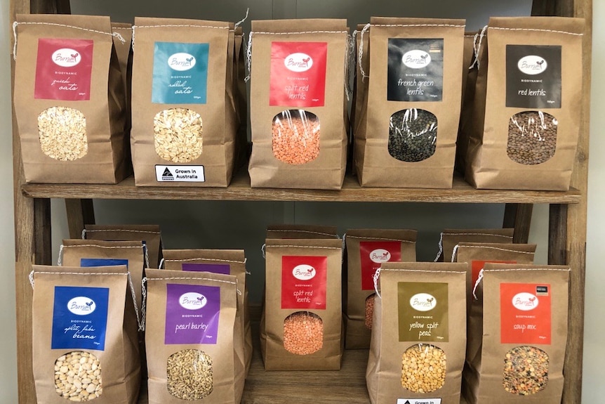 Various coloured packages of grain sit on shelf