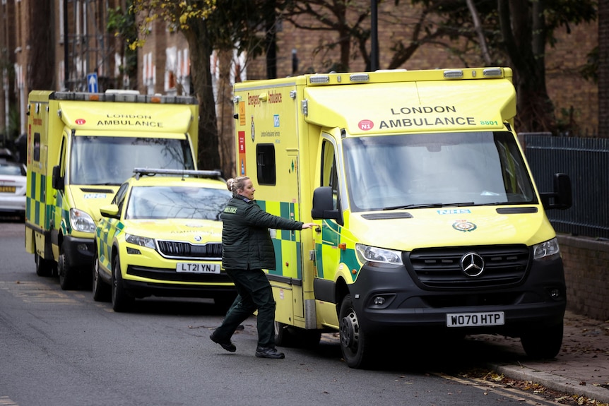 A female paramedic opens the door to an ambulance
