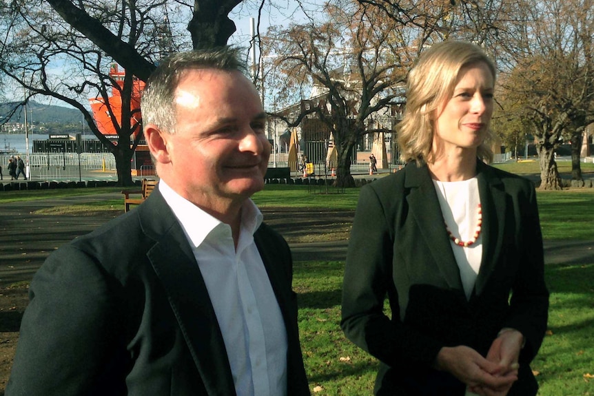 a man and a woman look to the right of the camera