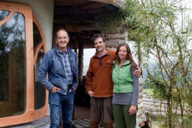Kevin McCloud from Grand Designs with the two home owners outside their "Hobbit house"