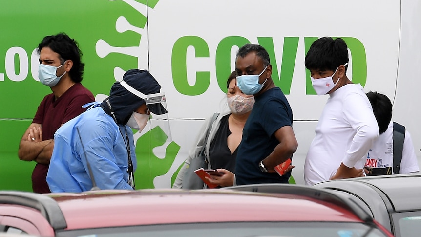 People watch as a man tests someone through a car window