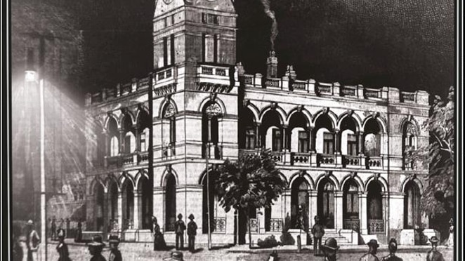 A historic drawing of Tamworth's post office lit up by a street light