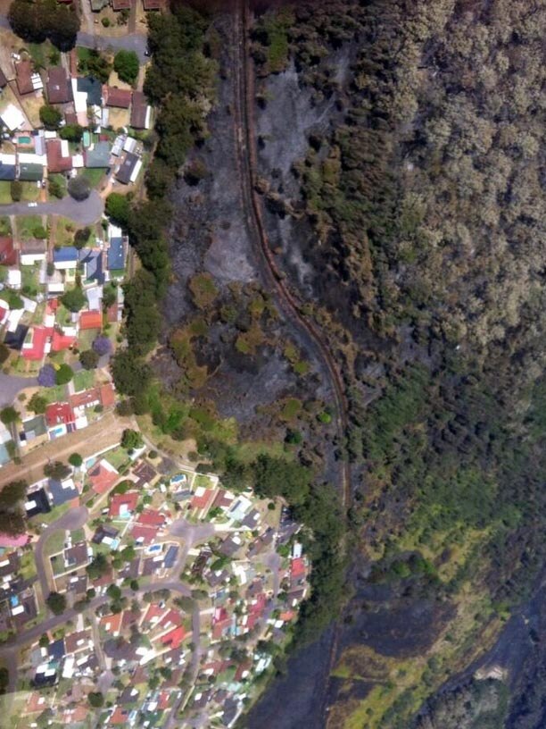 Aerial view of how close the fire came to homes at Raymond Terrace.