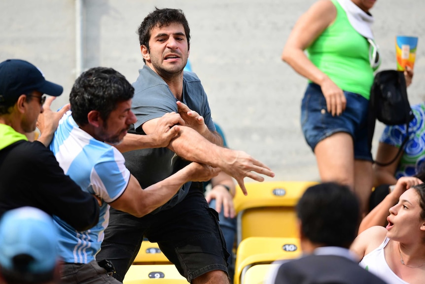 Argentina fan takes a swing at another crowd member at the Rio tennis