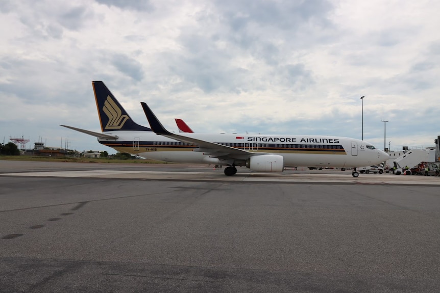 A photo of a plane grounded at an airport. It has Singapore Airlines branding.