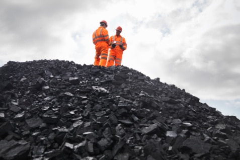 Coal miners on a pile of coal