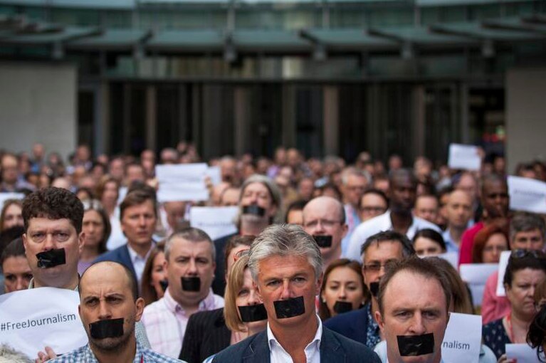 Staff from The Huffington Post Canada pose as part of the #FreeAJStaff campaign.