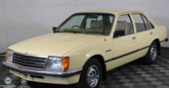 A cream coloured sedan with dark trim indoors