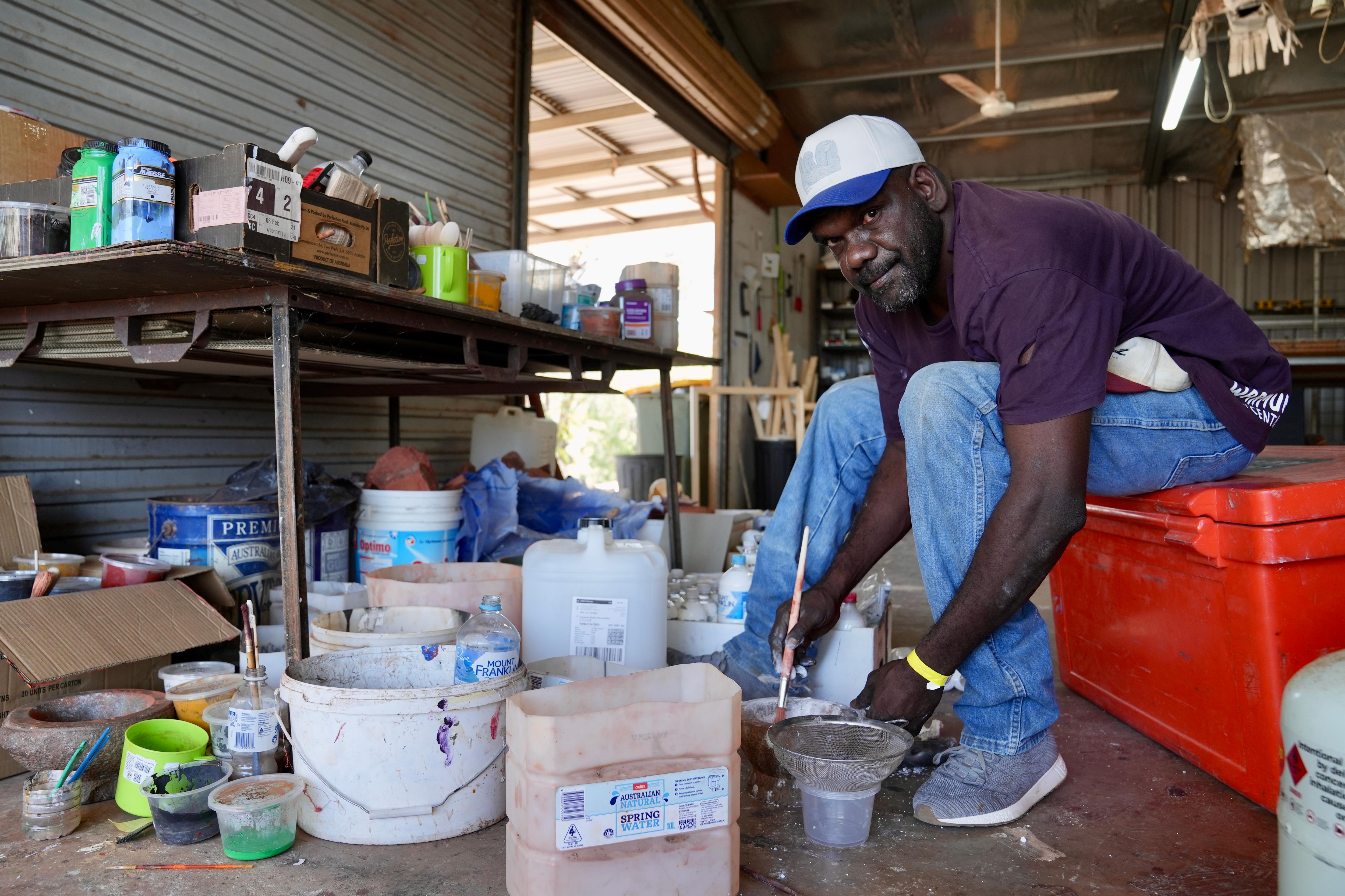 Aboriginal artist making ochre in a shed