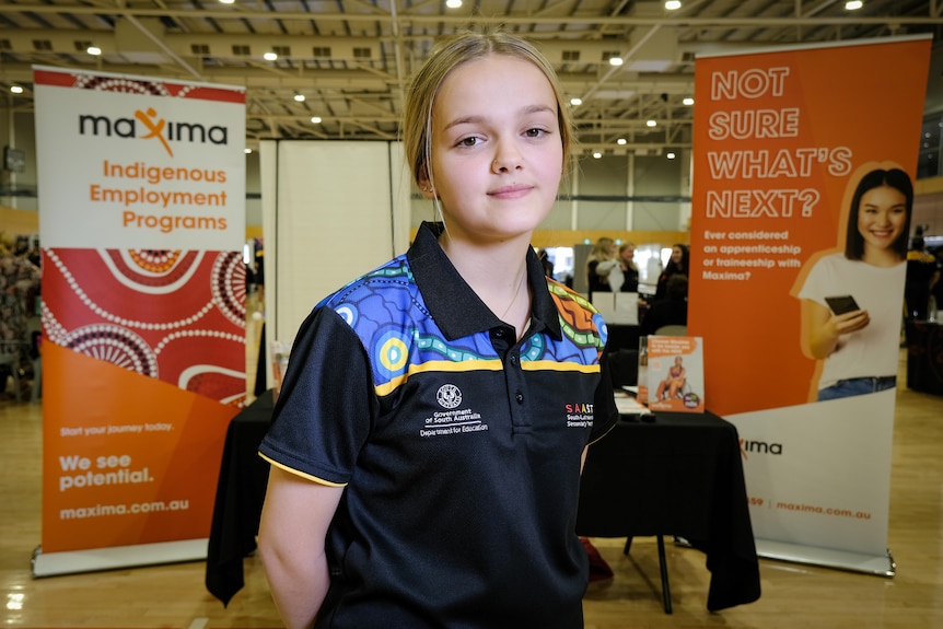 An Indigenous girl standing in front of a careers expo stall