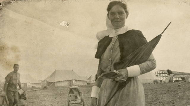 Matron Wilson on the island of Lemnos with a parasol and notebook in hand