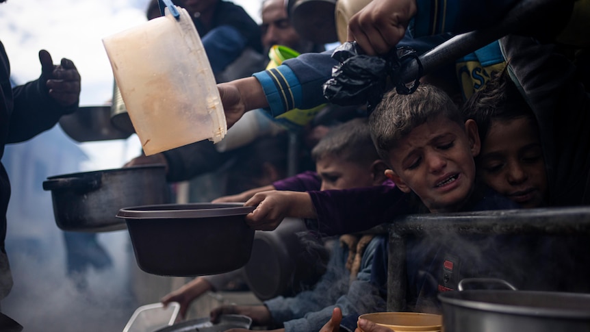 Palestinians line up for a meal in Gaza