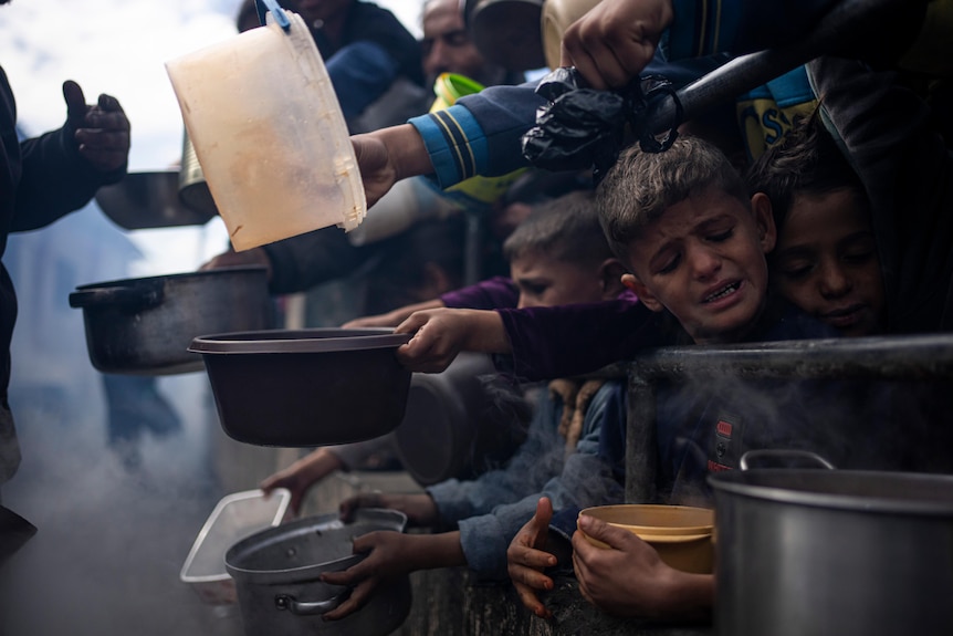 Palestinians line up for a meal in Gaza
