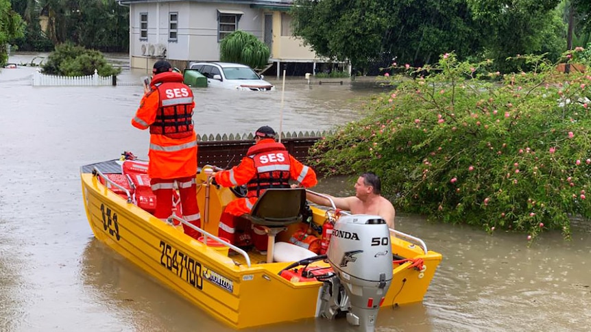 The SES rescuing a man from his flooded home in Townsville.