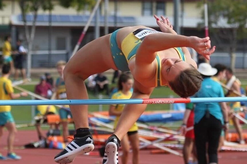 A young woman going over a high jump