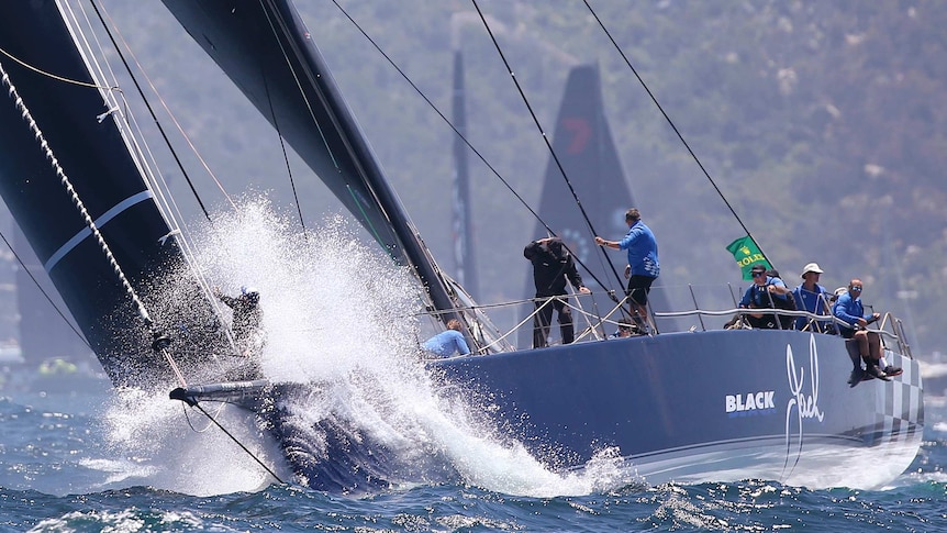 The bowman of Black Jack is sprayed with water early in the 2018 Sydney to Hobart.