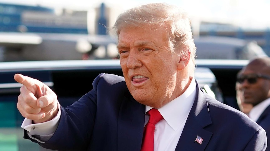 President Donald Trump gestures to supporters as he arrives at Minneapolis Saint Paul International Airport