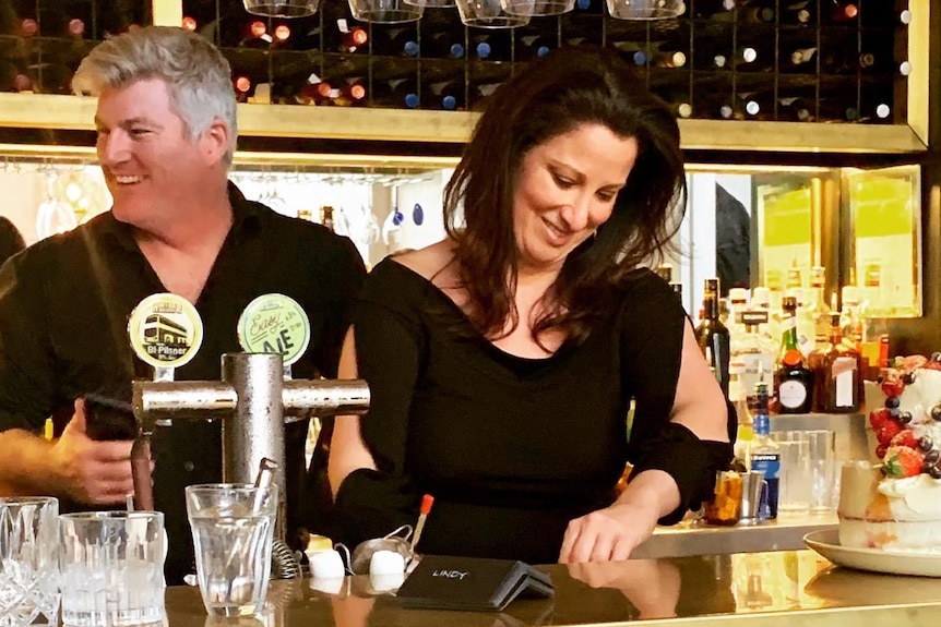 Stuart MacGill and Maria O'Meagher tend a bar.