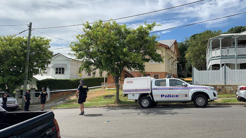 Police vehicles and officers at the scene of a suspicious death of a man at a residence in Hunter Street at Kelvin Grove.