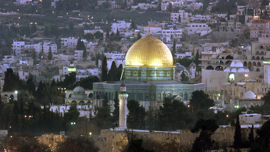 A skyline view of part of Jerusalem, with the Dome of the Rock illuminated.