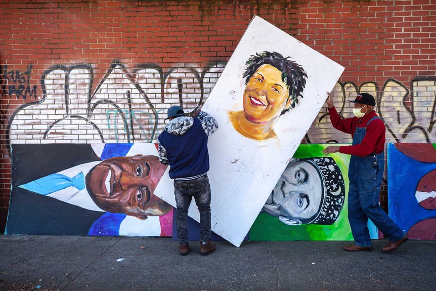 Artists set up a painting of Stacey Abrams.