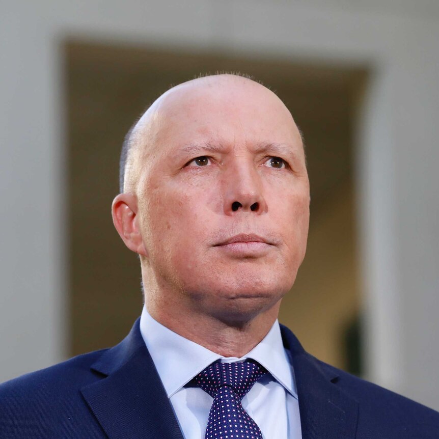 Peter Dutton looks into the distance.