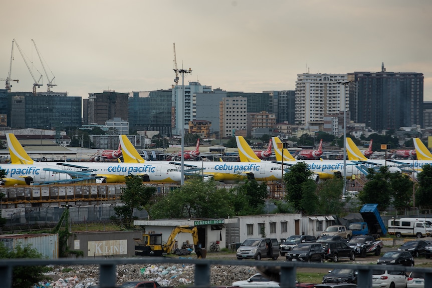 Planes, marked with Cebu Pacific branding, can be seen lined up in an urban environment
