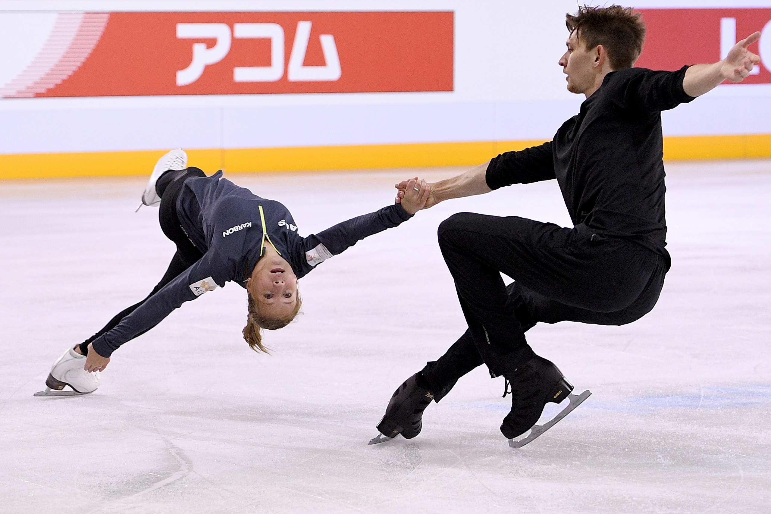 Harley and Katia skate during a practice session, as Harley holds Katia's hand while she performs a backbend.