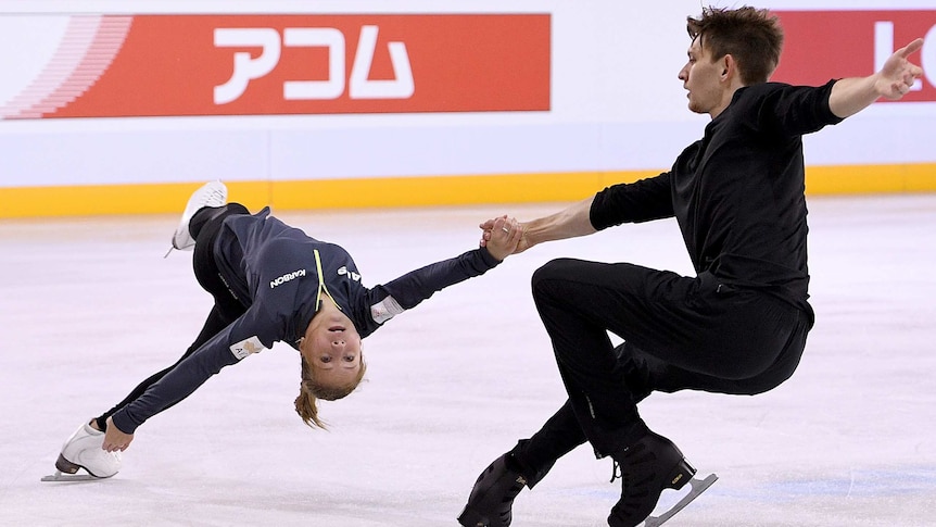 Harley and Katia skate during a practice session, as Harley holds Katia's hand while she performs a backbend.