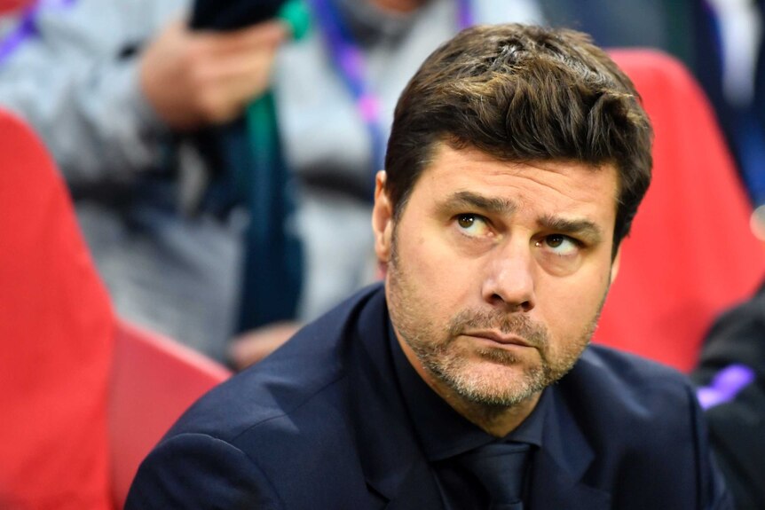 Tottenham manager Mauricio Pochettino sits in a matching dark suit and tie, looking up to the right, with a neutral expression.