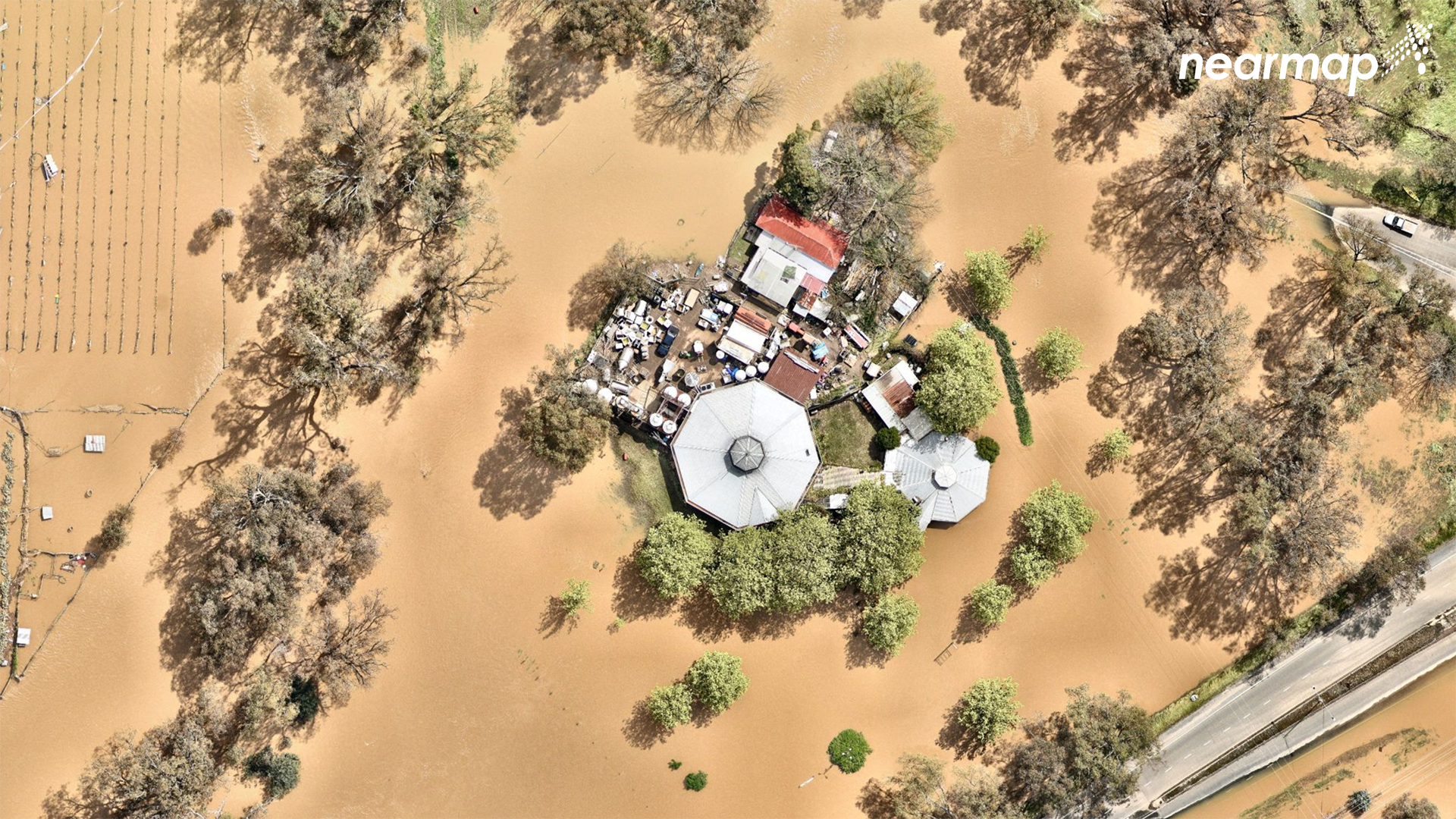 This house is surrounded by brown floodwater with paddocks and gardens lost to floodwater