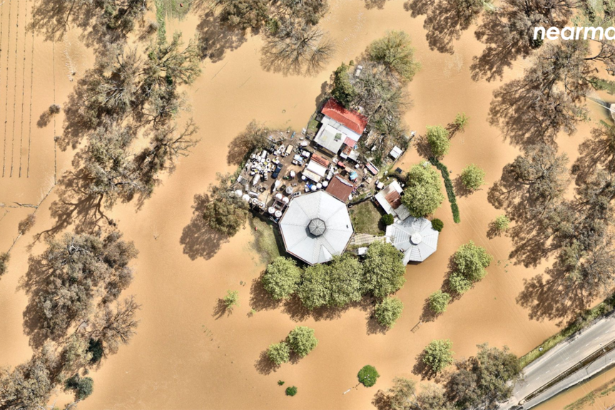 This house is surrounded by brown floodwater with paddocks and gardens lost to floodwater