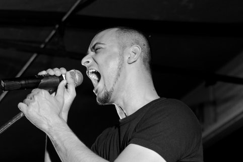 Shanul Sharma, eyes closed, mouth wide open, singing on stage