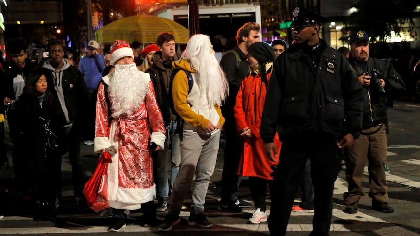 People in Halloween costumes stand near the scene