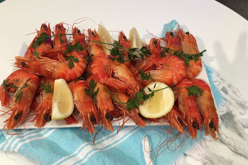 Plate of prawns with lemon and parsley garnish.