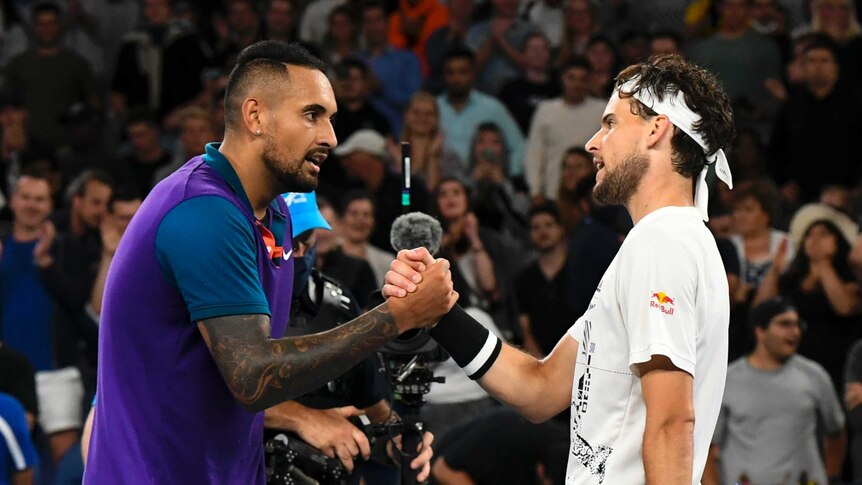 Nick Kyrgios and Dominic Thiem clasp hands over the net after their Australian Open tennis match.