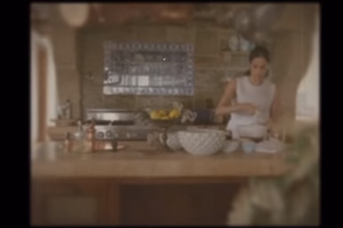 A grainy photo of a woman cooking in a kitchen 
