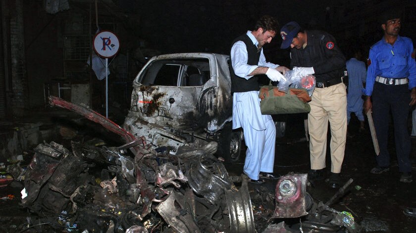 Police officials survey the site of a suicide bomb explosion in Pakistan